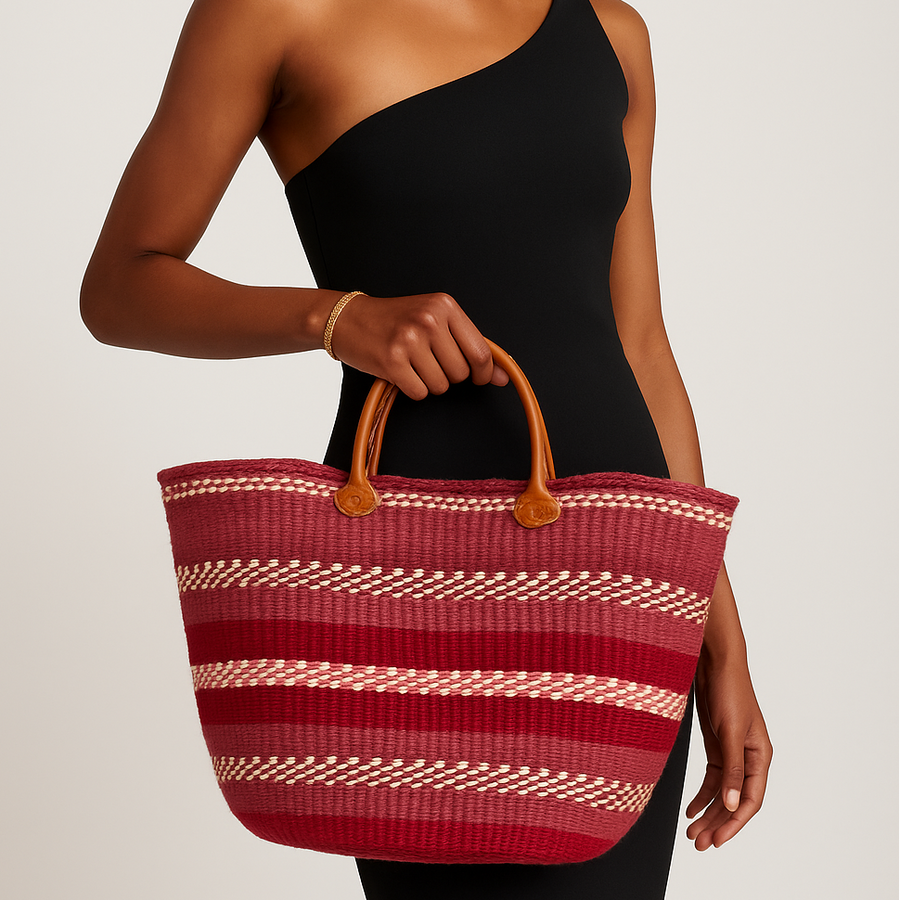 Woman holding a red and white striped bag against a neutral background