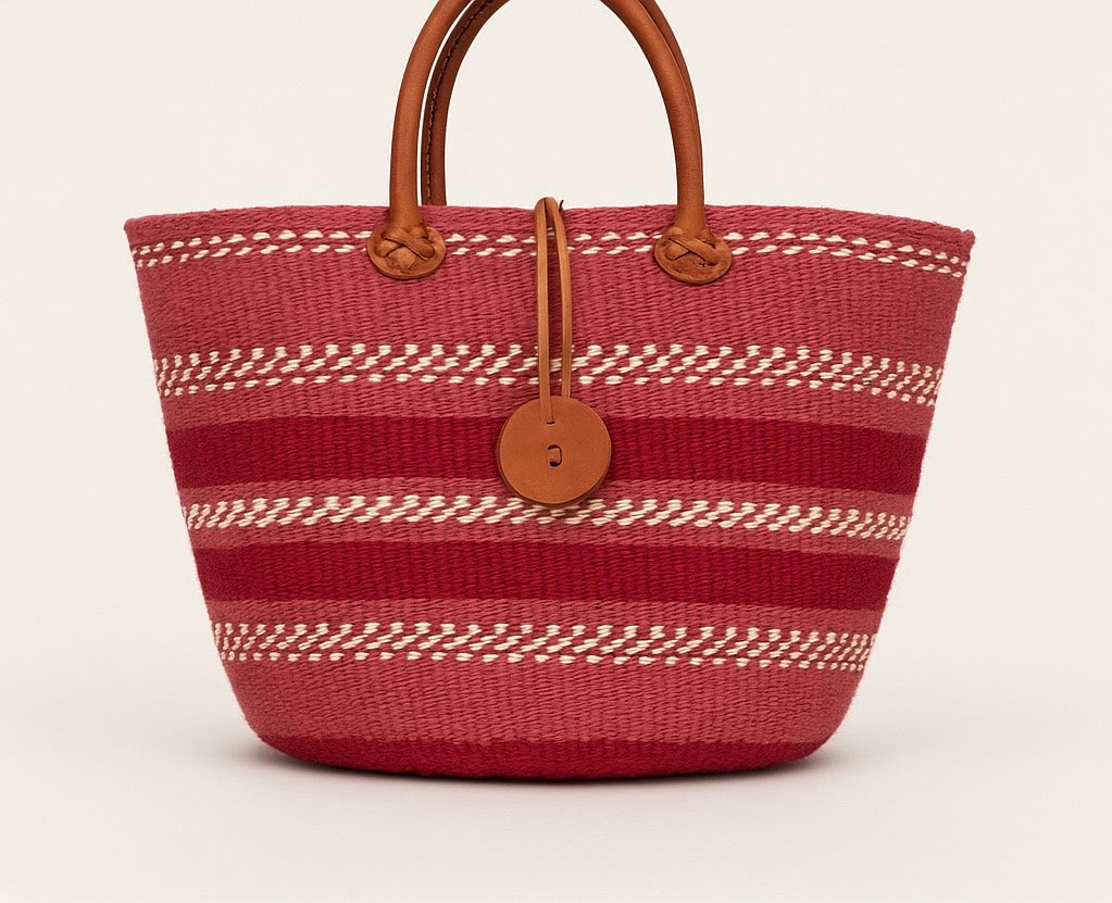 Red woven bag with brown handles and decorative elements on a light beige background
