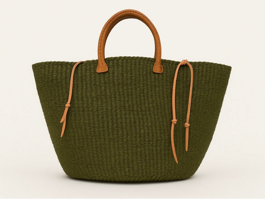 Green woven handbag with brown handles and straps on a white background