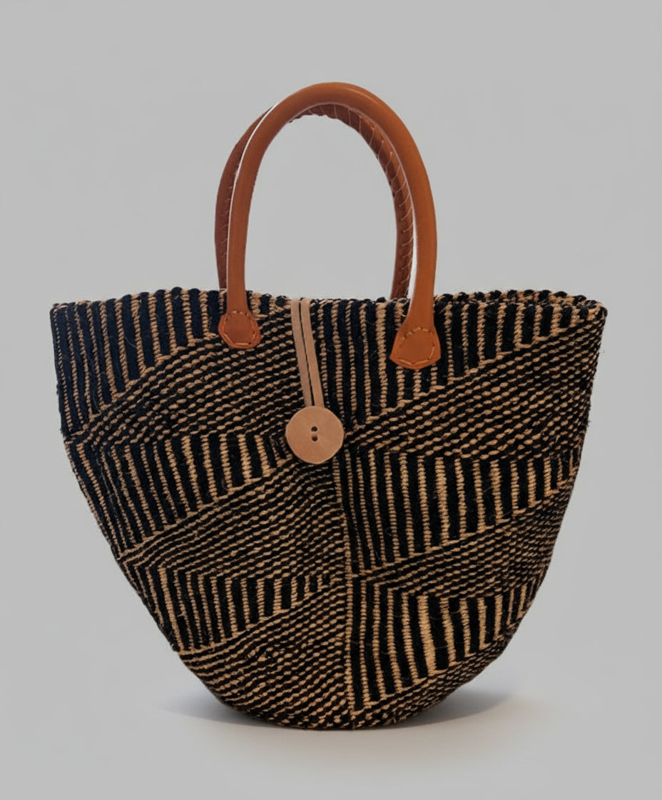 Woven handbag with brown handle and button on a gray background