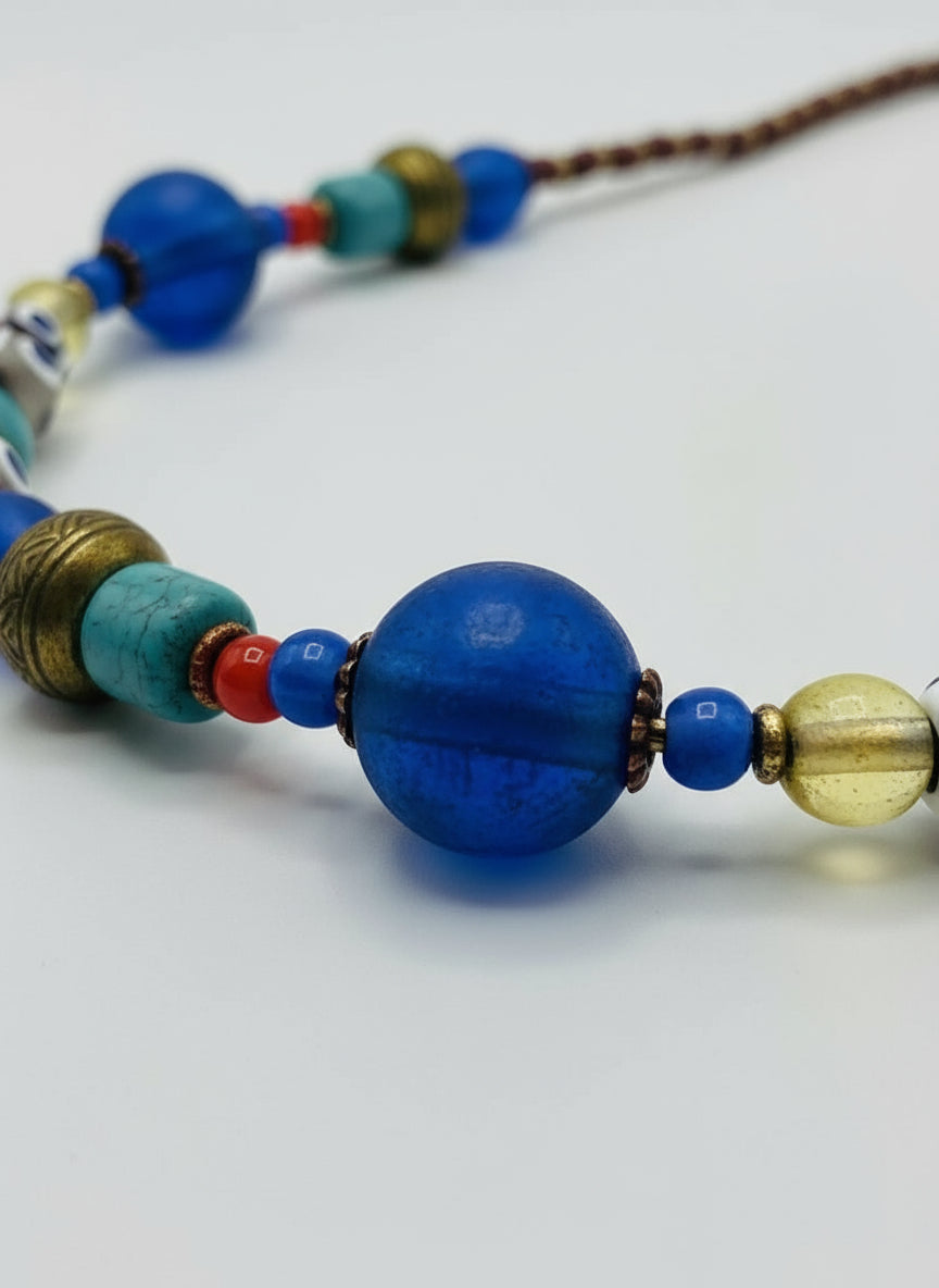 Necklace with blue, gold, and turquoise beads on a white background
