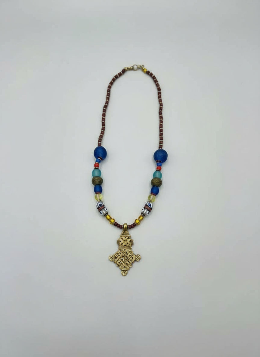 Necklace with beads and a gold pendant on a white background